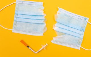 torn mask and bent vaccine needle