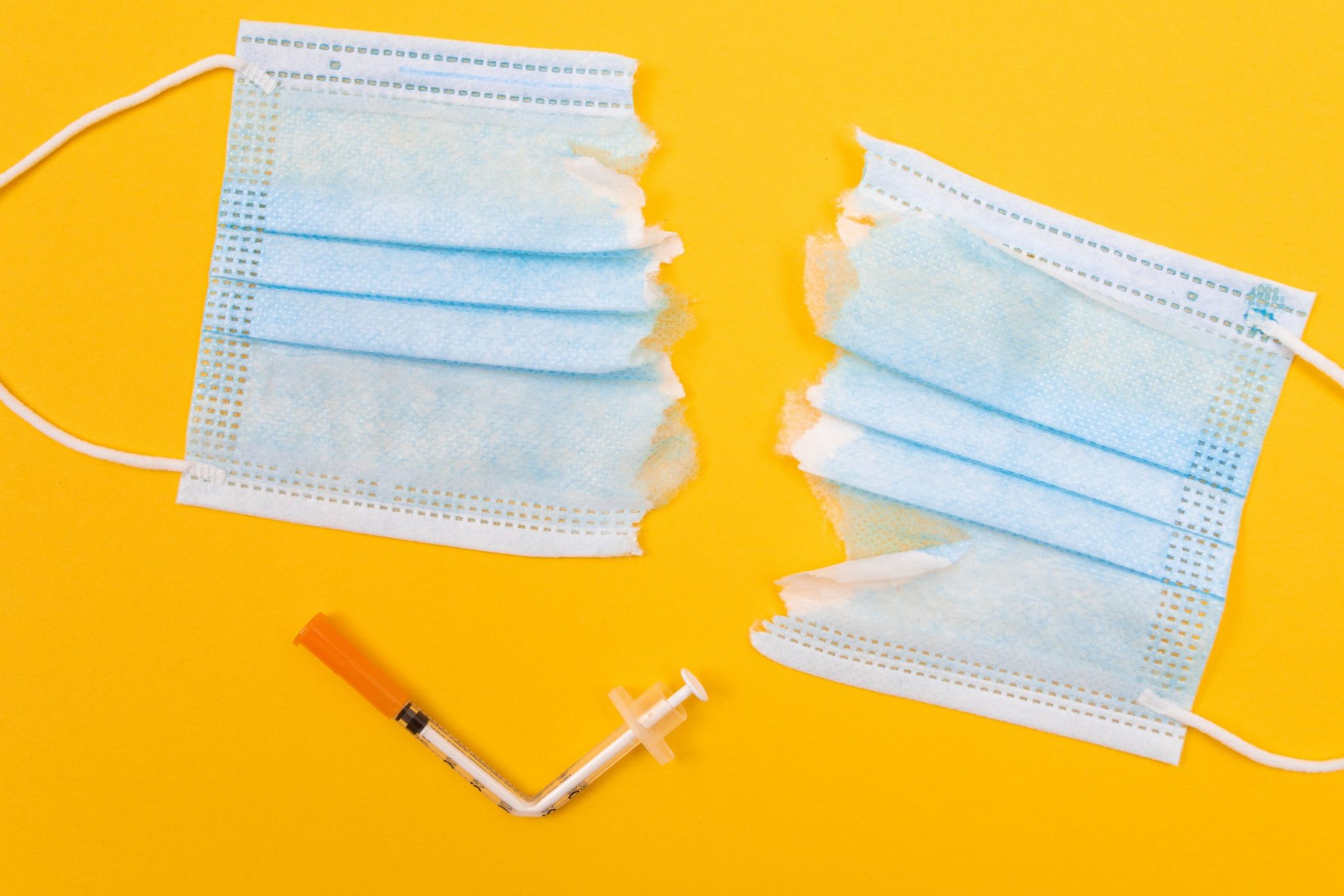 torn mask and bent vaccine needle