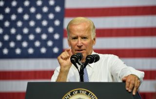 Joe Biden delivers a speech in front of an American flag