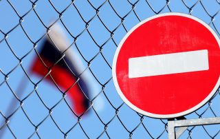 Flag of Russia behind a fence with a forbidding sign brick