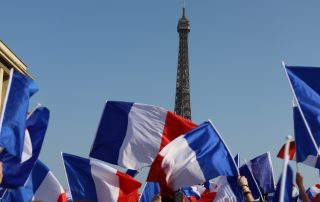 Paris , france - march 24 2022 : crowd cheering and waving french flags at Zemmour political rally in front of Eiffel tower , motion blu