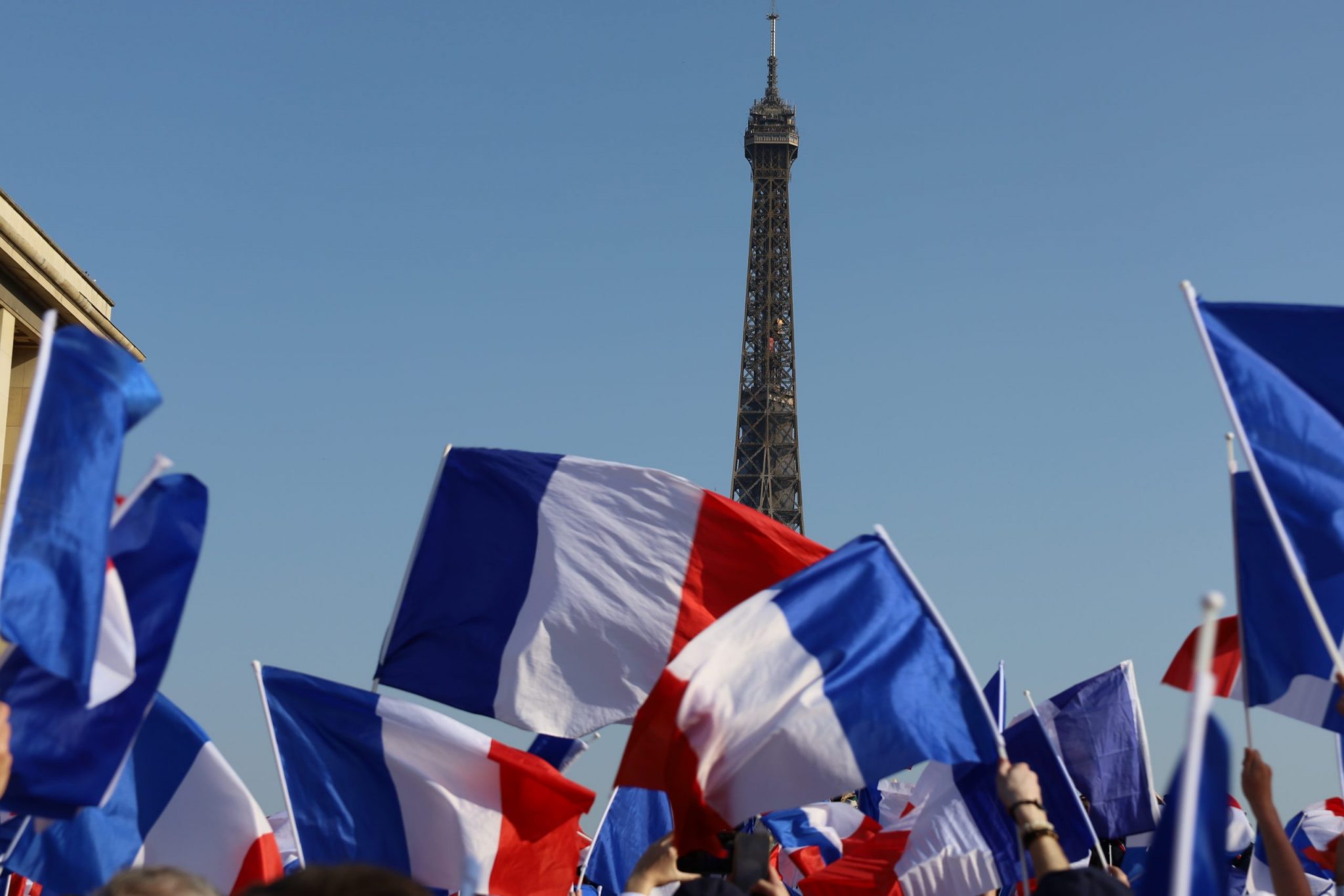 Paris , france - march 24 2022 : crowd cheering and waving french flags at Zemmour political rally in front of Eiffel tower , motion blu