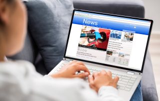 Watching News On Laptop Computer Screen Online At Home