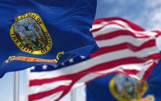 The Idaho state flag waving along with the national flag of the United States of America.