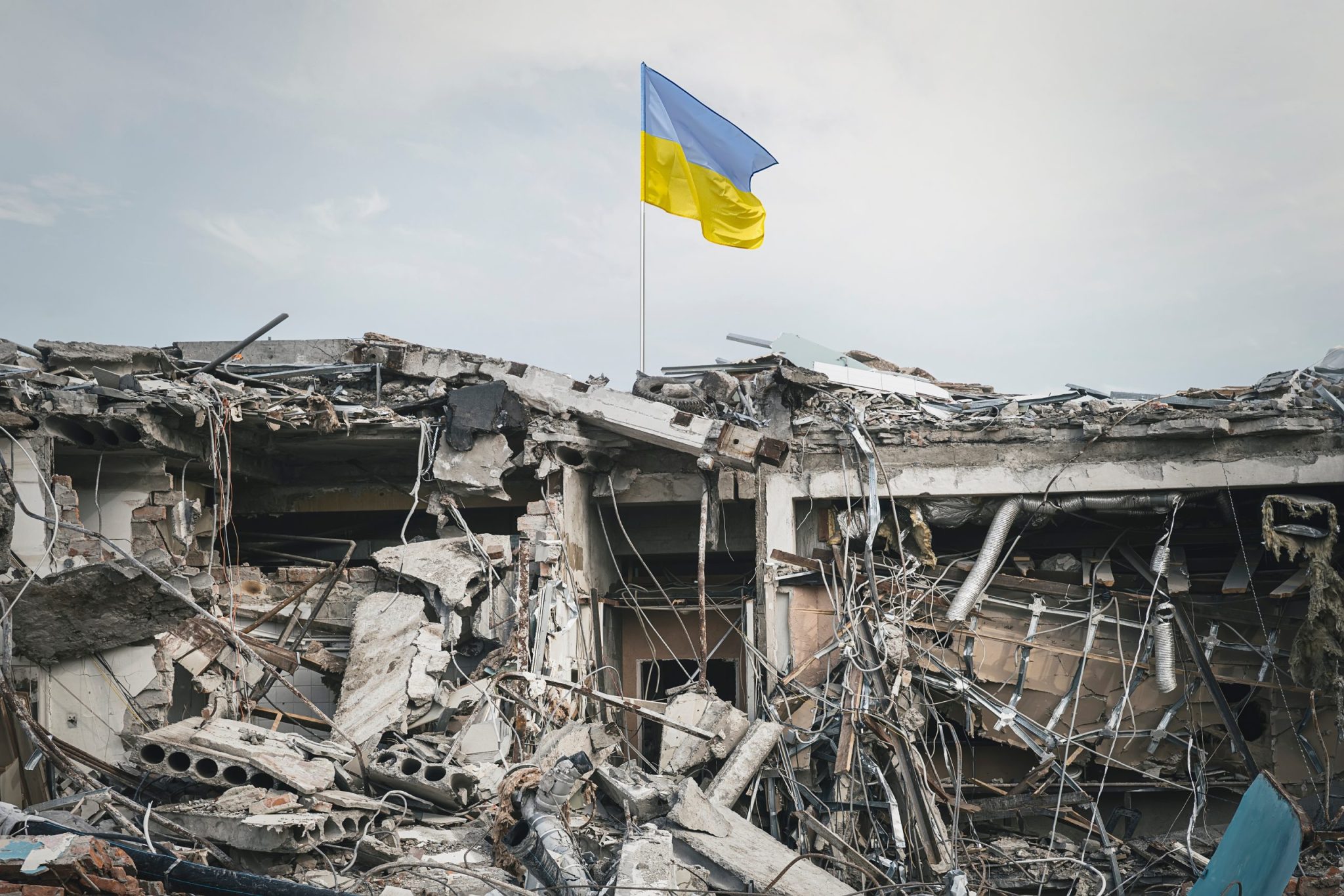 the wreckage of the building and the Ukrainian flag