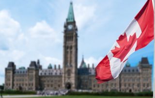 Canadian flag waving with Parliament Buildings hill in the background Ottawa,Ontario, Canada